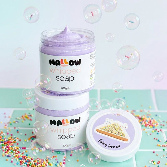 Two jars of Mallow Whipped Soap stacked on top of each other, with one jar open to show the lavender whipped soap inside. A separate lid labeled 'Fairy bread' sits beside them.