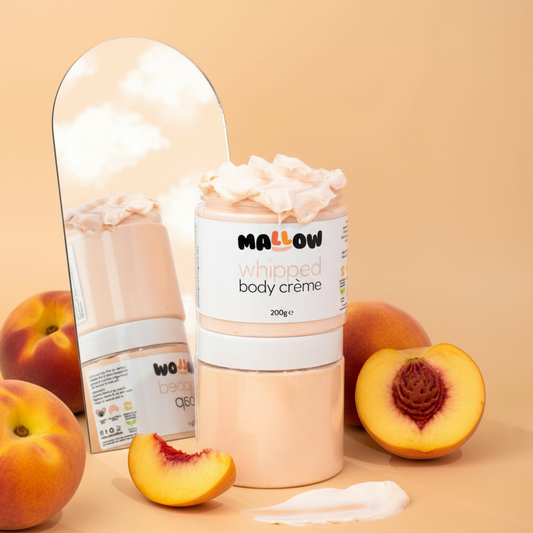 Mallow Peach whipped body crème with peach slices on a beige background