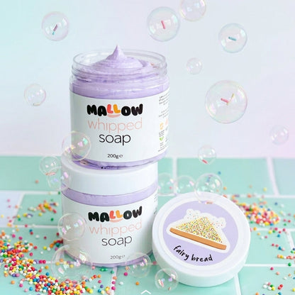 Two jars of Mallow Whipped Soap stacked on top of each other, with one jar open to show the lavender whipped soap inside. A separate lid labeled 'Fairy bread' sits beside them.